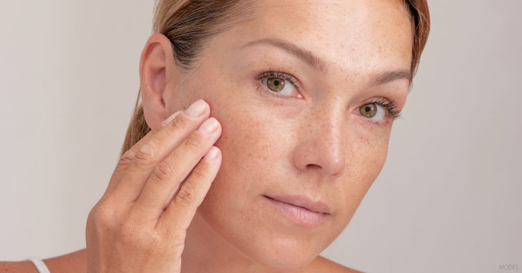 Woman examining her skin. (Model)
